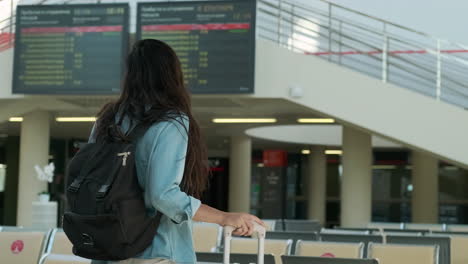 woman with backpack and suitcase at airport