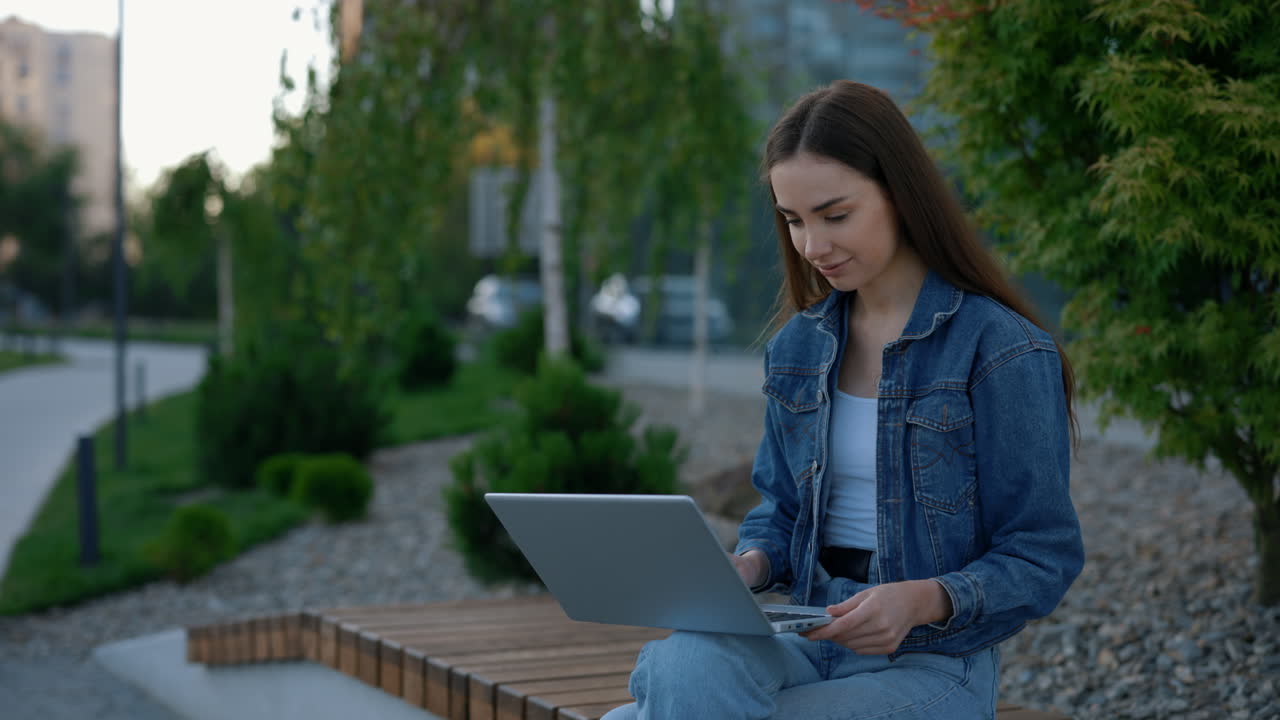 mujer joven trabajando en una computadora portátil al aire libre