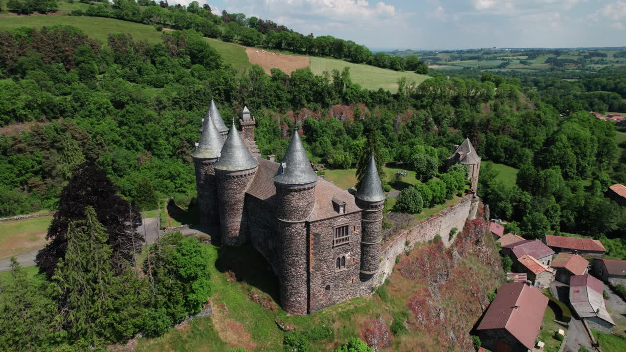 aerial shot around Sailhant Castle on a sunny day in the city of Andelat, Cantal departement, Auvergne Rhone Alpes region, France