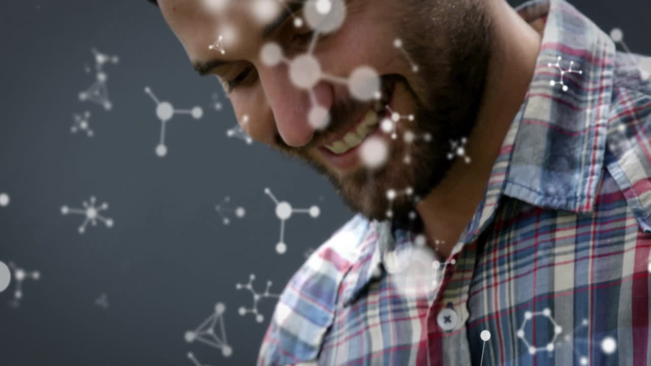 man wearing plaid shirt smiling and interacting with molecular graphics for science education