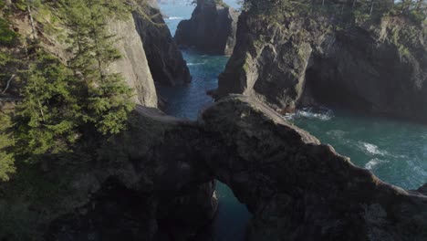 Natural-Bridges-Arch-on-Rocky-Oregon-Coastline---Aerial-Tilt-up