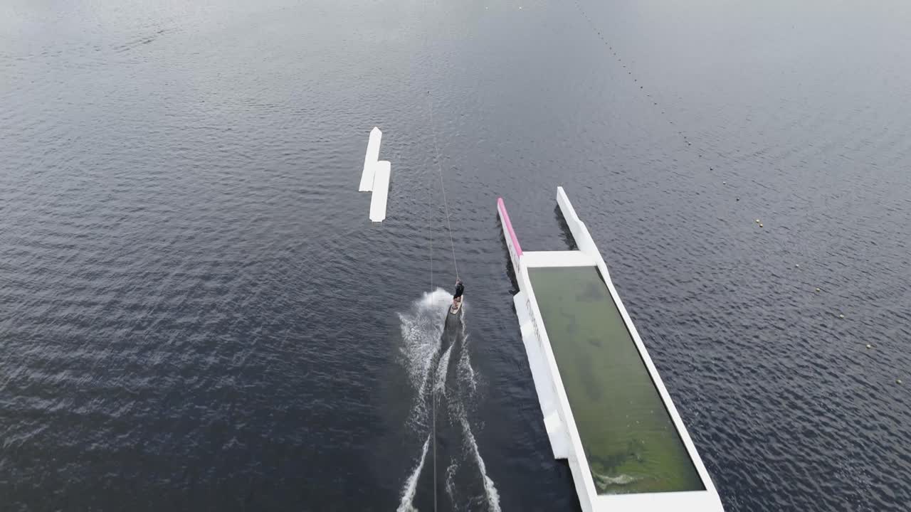 Drone footage of a person riding a jet ski across open water, symbolizing summer, leisure, and watersport activities