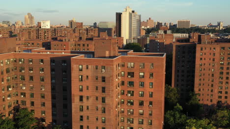 cinematic aerial trucking shot along public housing project buildings in harlem new york city just after sunrise