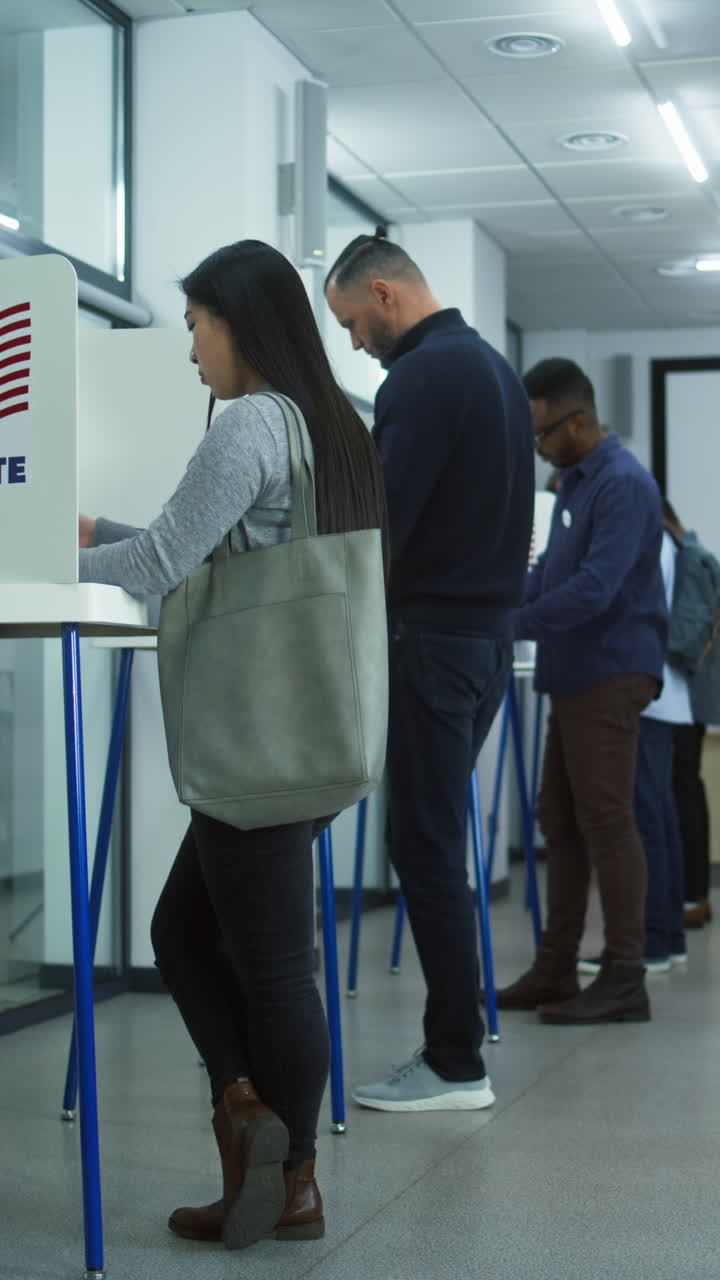 카우카스 여성 유권자가 투표 상자에 투표용지를 넣습니다.다양한 사람들이, 미국 시민들은 투표소에서 미래의 대통령을 위해 투표합니다.미국의 선거 날.민주주의.