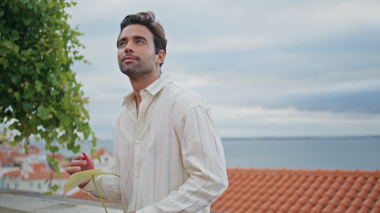 un chico romántico mirando desde la distancia al cielo nublado en primer plano. un macho esperando a su novia.