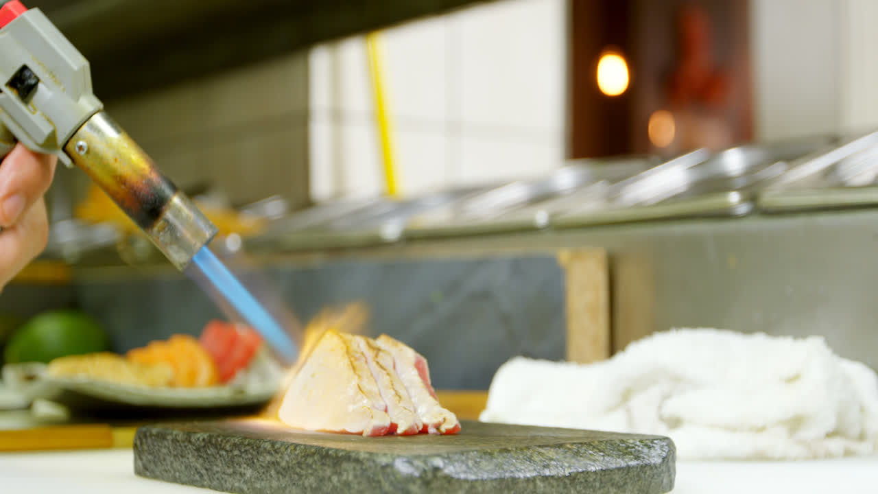 chef masculino calentando sushi en la cocina 4k