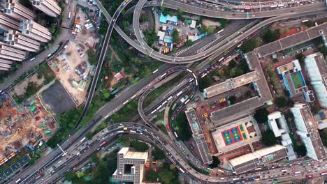 Vista-De-Arriba-Hacia-Abajo-De-Un-Tráfico-En-Una-Concurrida-Intersección-De-Carreteras-Con-Vías-Férreas-En-El-Abarrotado-Distrito-De-Kowloon-En-Hong-Kong