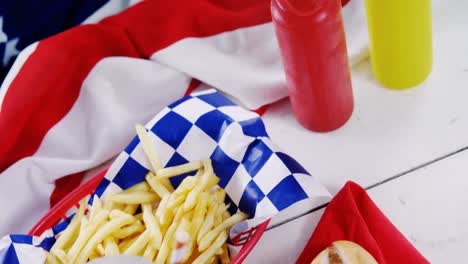 hot dog, french fries and cold drink served on a table with 4th july theme