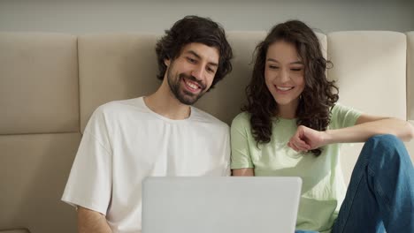 una pareja encantadora saludando a alguien en una videollamada