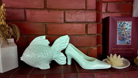 whimsical ceramic fish and high heel figurines on a mantlepiece