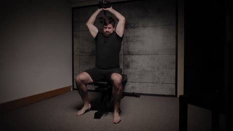 trituradoras de cráneo con mancuernas sentadas extensiones de tríceps, iluminación cinematográfica, hombre blanco vestido con ropa de gimnasio negra