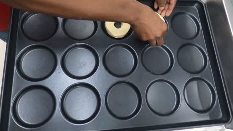 rosquillas crudas en una bandeja negra listas para hornear vista superior movimiento suave 4k videoclip.