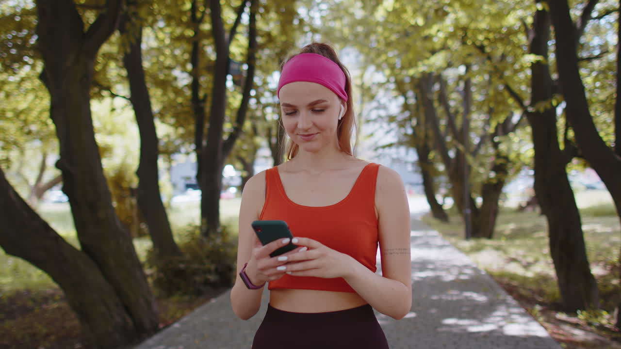 운동 피트니스 스포츠 달리기 여자 걸어, 스마트폰을 사용하여 공원에서 헤드폰으로 음악을 듣고