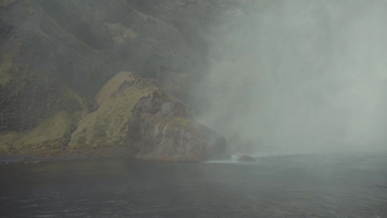 Thick Mist and Spray Rising from a Powerful Waterfall on a Rocky Coast