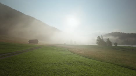 lonely german farm hut in fog during sunrise, static shot