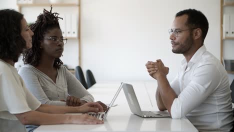 smiling people talking and shaking hands at office