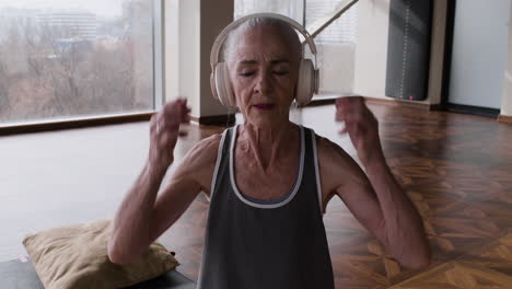 senior woman meditating with headphones