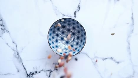 mixed nuts and seeds in a blue and white bowl