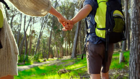 couple holding hands while running in the forest 4k