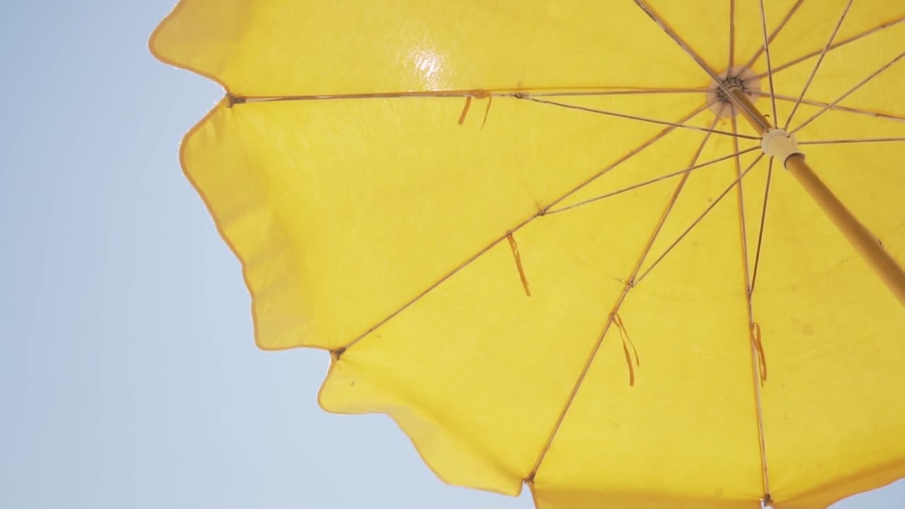 은 하늘 아래 노란색 해변 우산