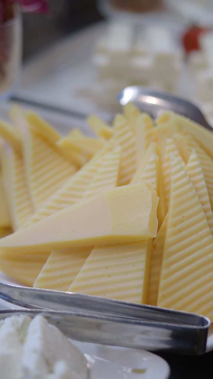 Triangular Cheese Slices on a White Platter at a Buffet