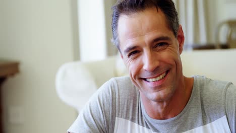 Portrait-of-smiling-man-in-living-room