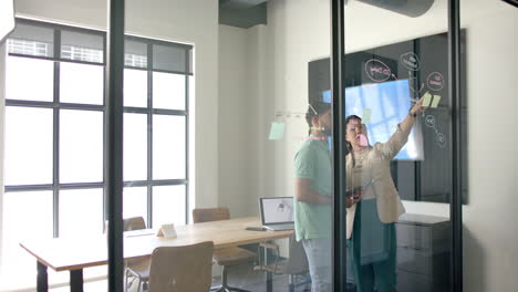 brainstorming with digital whiteboard and laptop, colleagues collaborating in modern office