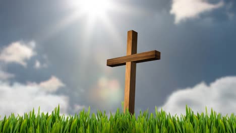 Animation-of-christian-cross-in-grass-over-sun-shining-on-blue-sky-with-clouds