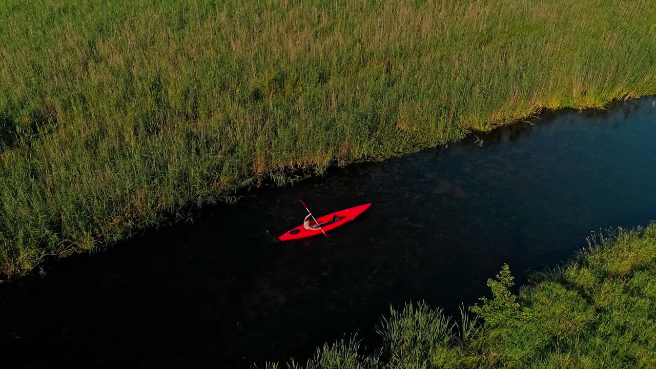 Aerial view of woman rowing in a kayak on the river on a warm summer day