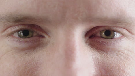 close up of man green eyes opening caucasian male awake looking happy at camera iris focus