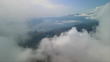 drone view flying through the clouds over mount lovcen, montenegro