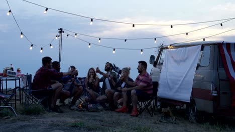 friends having rest in campsite having drinks