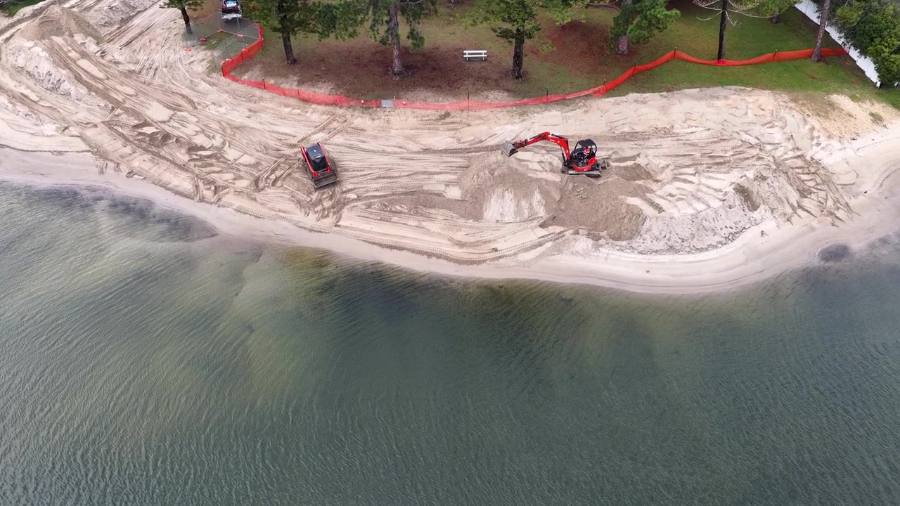 Riprese con drone mostrano escavatori che spostano sabbia durante un progetto di riqualificazione del lungomare sulla Gold Coast