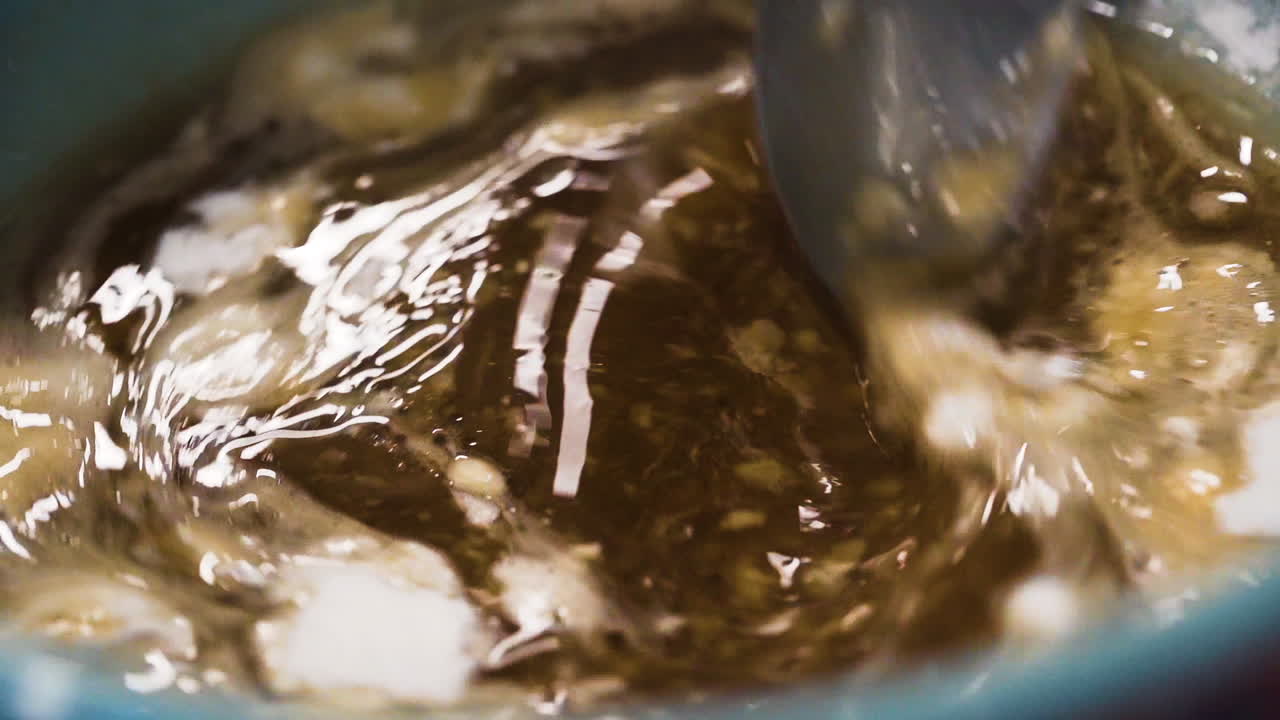 Pasticciere che mescola una ciotola di estratto di vaniglia in una cucina