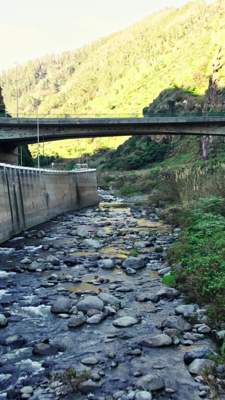 River flowing under a bridge in a mountainous area
