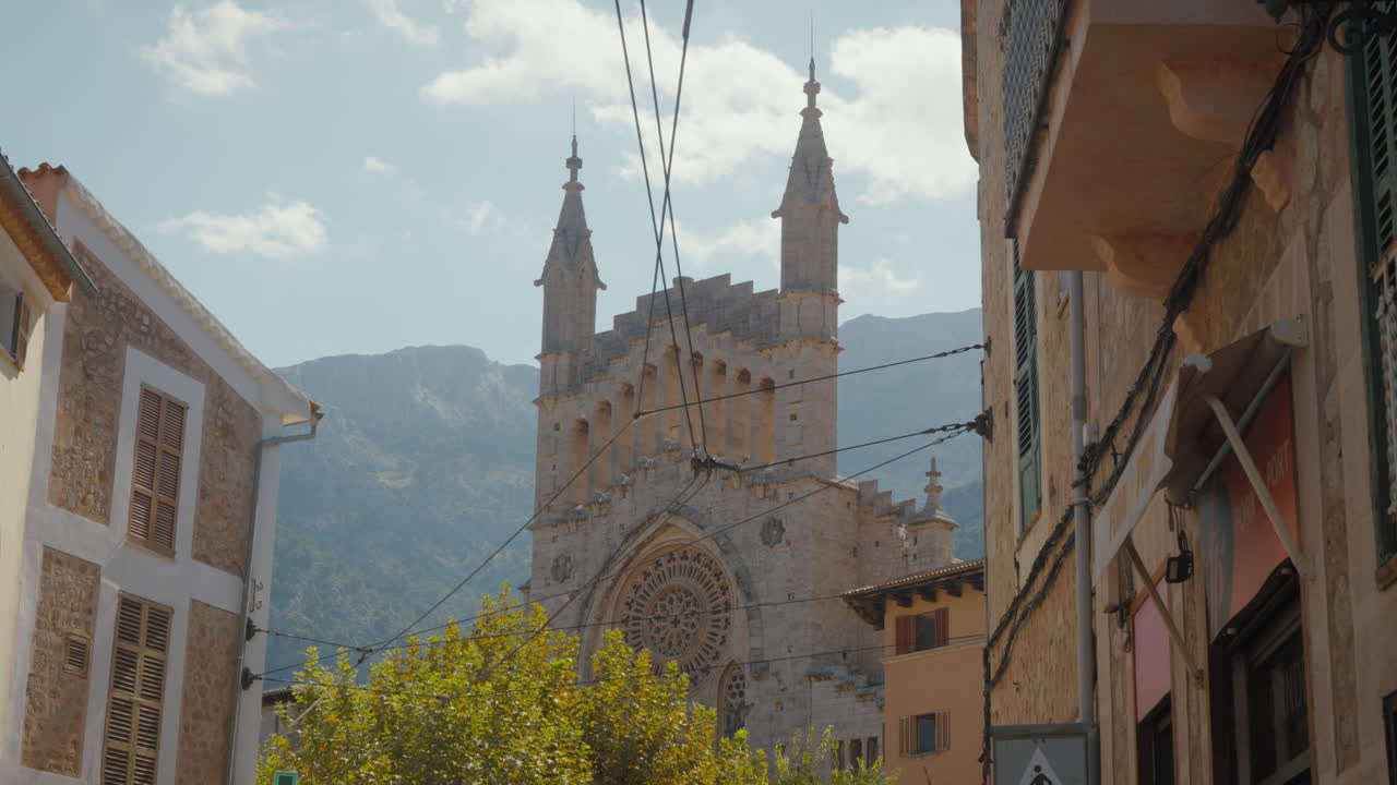 Encantadora vista de calle de Sóller con impresionante arquitectura de iglesia. Ideal para vídeos de viajes y documentales.