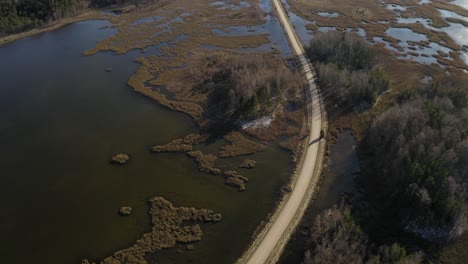 Aerial-tilt-down-on-two-lakes-along-road-in-Latvia