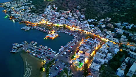 aerial view circling the illuminated eloúnta village, dusk in crete, greece