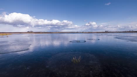 white clouds floating on the blue sky, which is reflected in the beautiful and clear water of the river