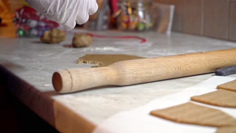 Push-in-shot-,-close-up-on-caucasian-woman's-hands-wearing-since-use-white-latex-gloves,-preparing-gingerbread-homemade-cookies-4K