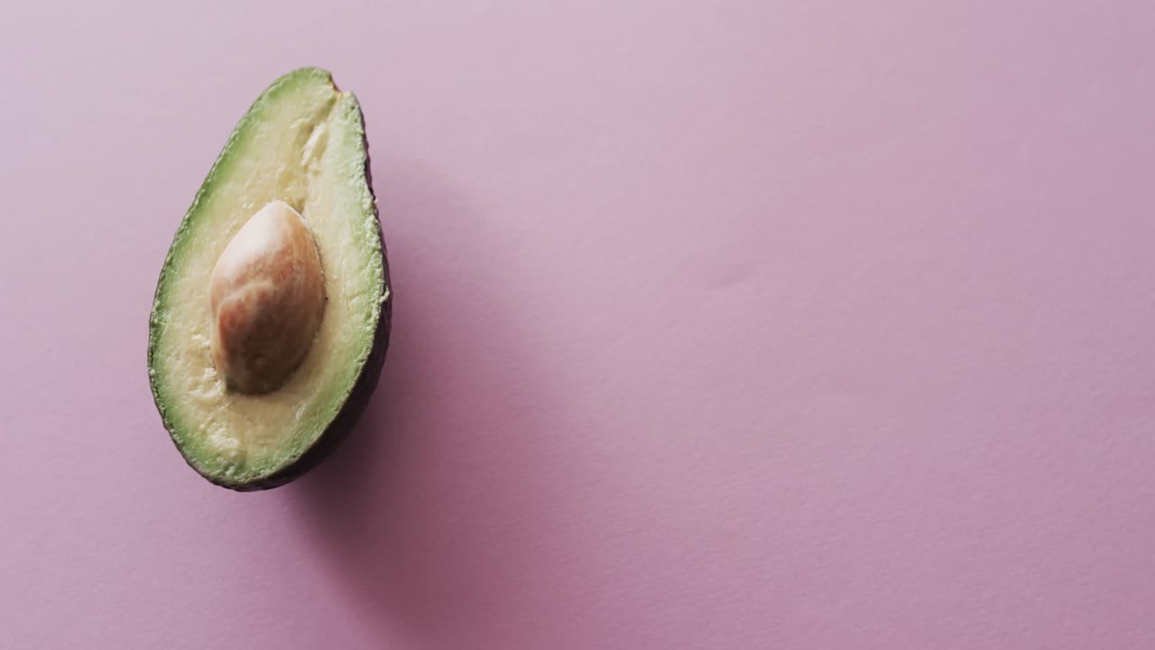 Video di avocado a fette con spazio per il testo su sfondo rosa