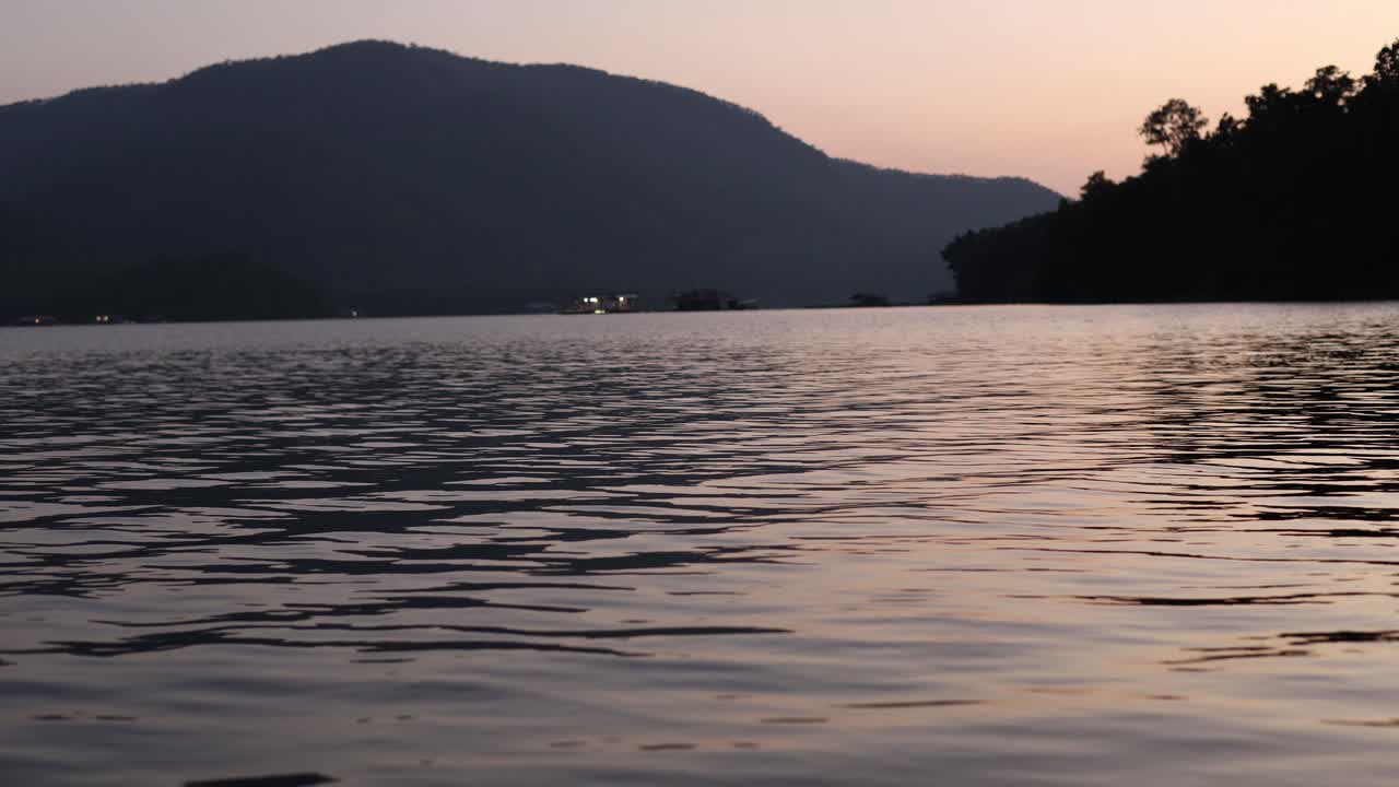 산 의 실루 을 가진 조용 한 호수 위 의 해 가 지는 것