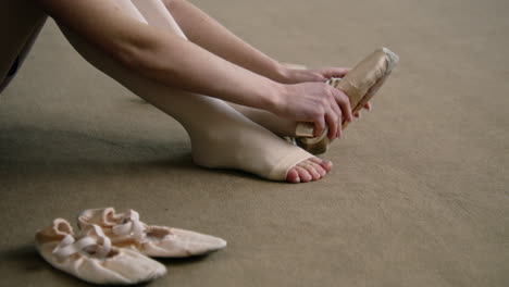 una bailarina que se pone zapatos de punta