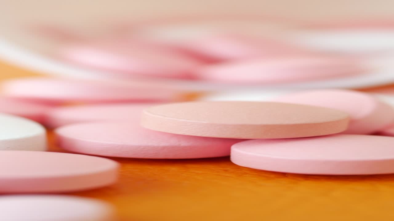 pastillas rosas y blancas en superficie naranja