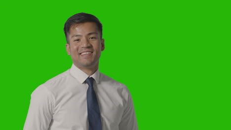 portrait of businessman in shirt and tie against green screen smiling at camera 3