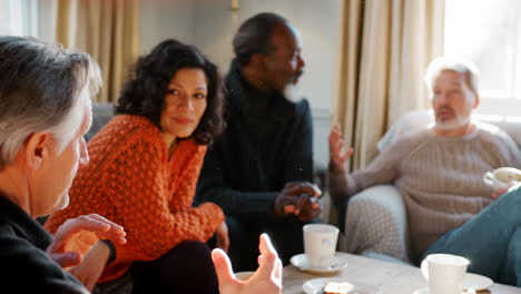 Group-Of-Middle-Aged-Friends-Meeting-Around-Table-In-Coffee-Shop