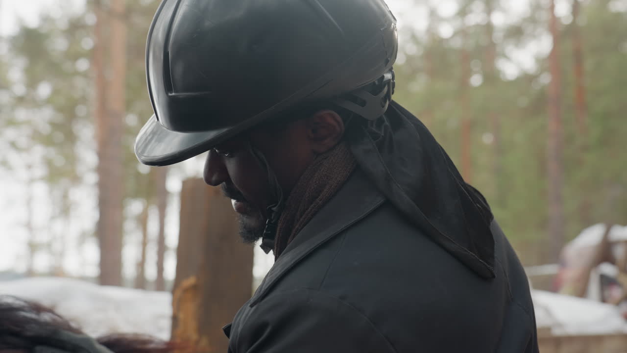 야외에서 말을 검사하는 모습, 조련사가 눈 속에서 말을 관찰하고, 어떤 사람이 겨울 숲 속 마구간에서 말을 살펴보고, 한 사람이 보호 장비를 착용한 채 눈 덮인 숲 속에서 말을 확인하는 모습