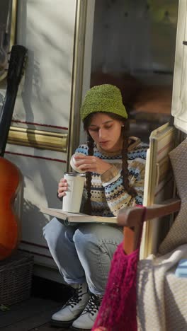 teenage girl reading a book in a camping van