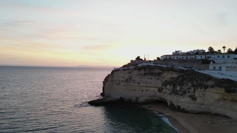 spectacular drone footage flying along the cliffs at carvoeiro algarve portugal at golden hour sunset with stunning colors and the mediterranean sea to the left