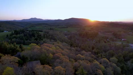 aerial-push-over-spring-growth-toward-grandfather-mountain-sunset-near-boone-and-blowing-rock-nc,-north-carolina